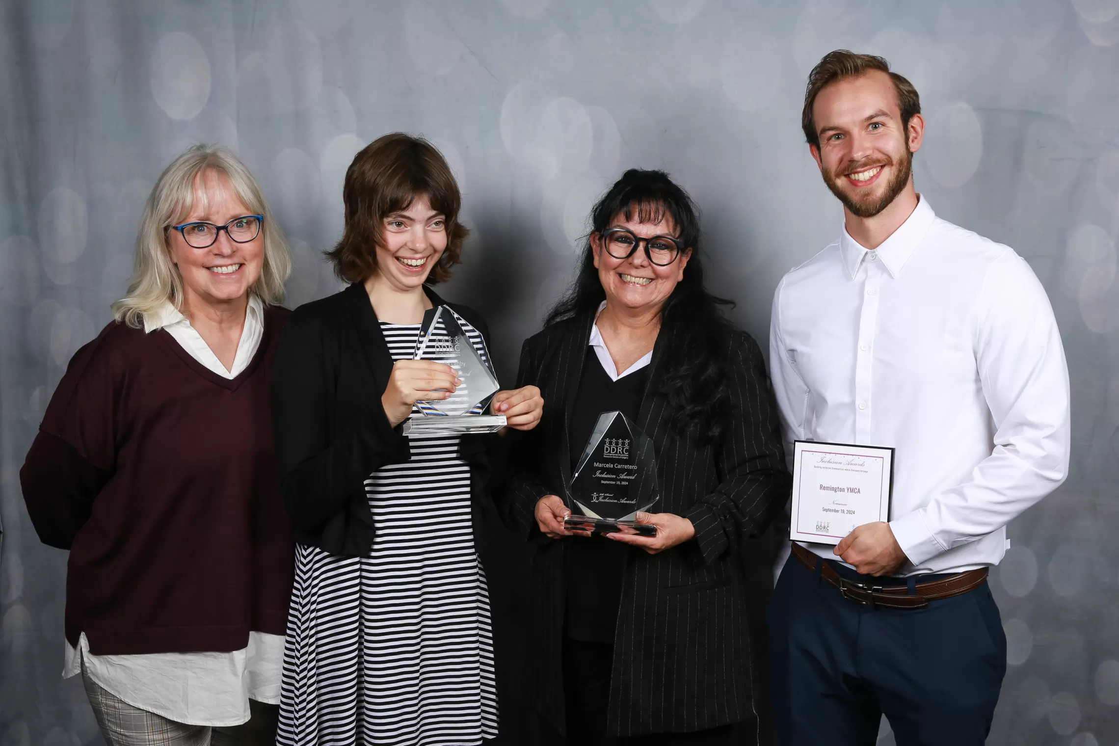 A group of individuals pose with awards